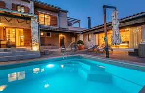 Relax by the serene pool surrounded by comfortable lounge chairs and a well-maintained patio.