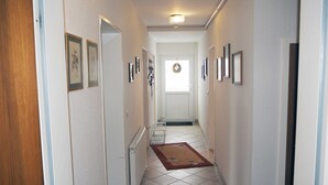 A hallway with a radiator, a door, and a rug. - Vacation apartment Niewand (Clausthal-Zellerfeld)