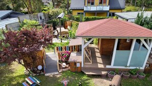 A residential property with a covered patio, a small play area, and a green slide. - Apartment 3 - Vacation Home Strandstr. 29 (Loddin)