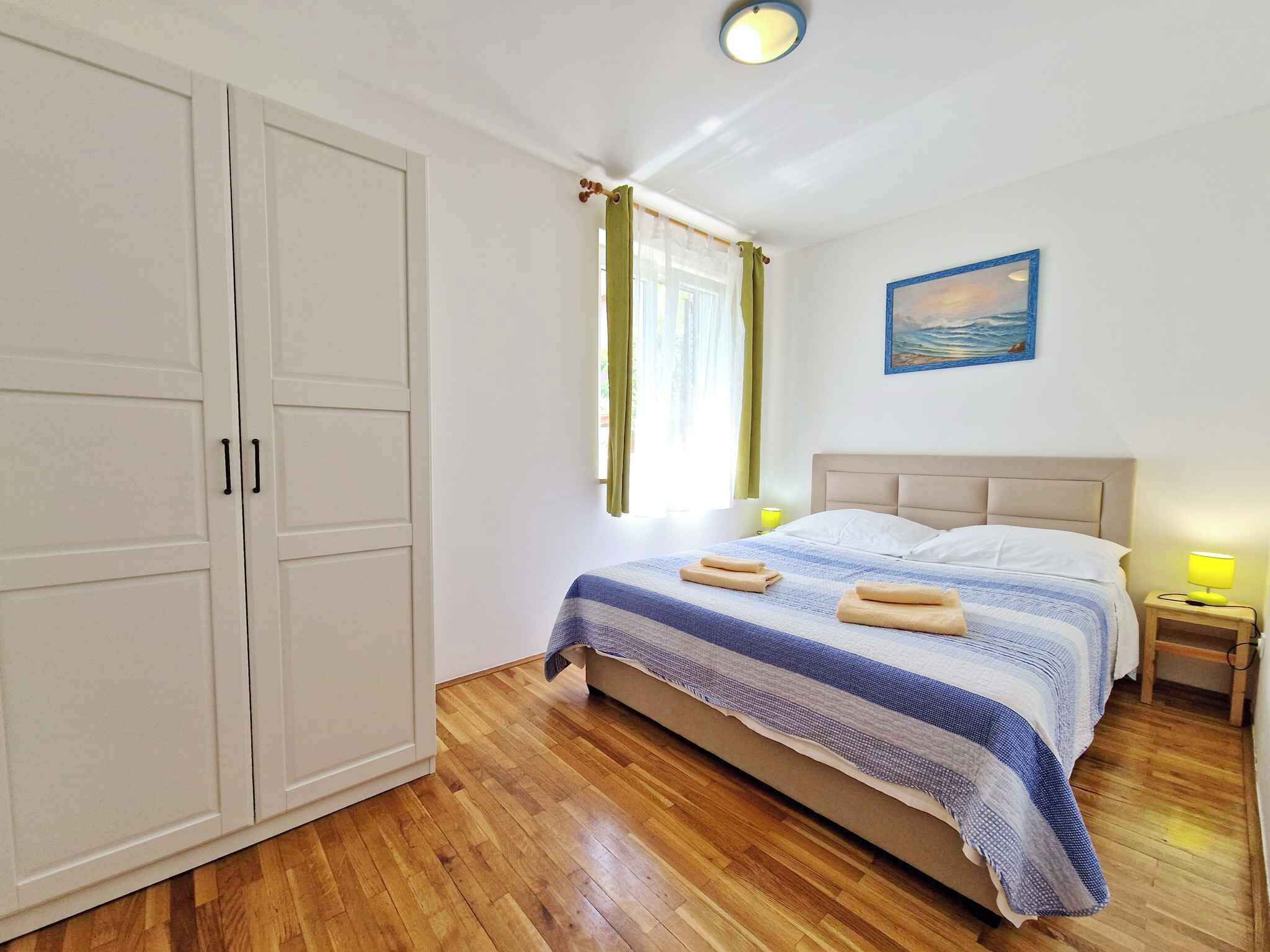 Ein Schlafzimmer mit einem Bett, einem Nachttisch, einer Lampe, einem Gemälde und einem Kleiderschrank.