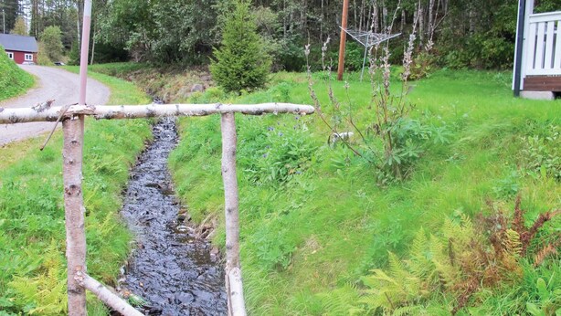 Een landelijk buitengebied met een houten constructie boven een beek.