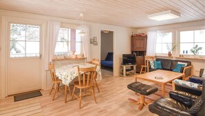 Een gezellige woonkamer met een eethoek, een bank en een televisie.