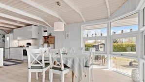 Una cocina amplia con muebles blancos y una zona de comedor con mesa y sillas.