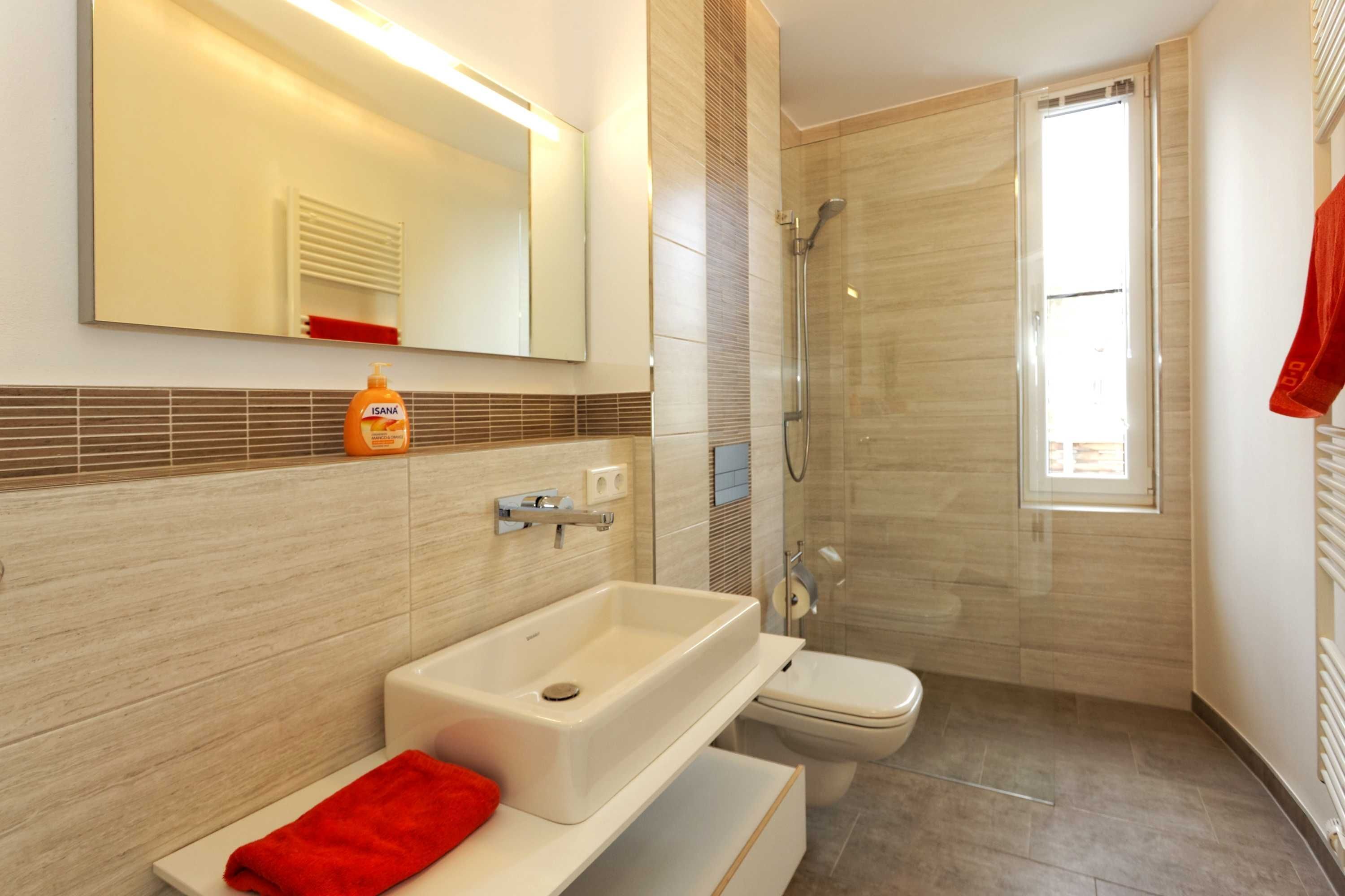 Ein modernes Badezimmer mit Badewanne, Waschbecken und Toilette.
