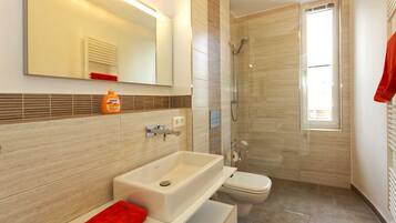 Ein modernes Badezimmer mit Badewanne, Waschbecken und Toilette.