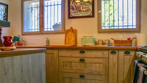Una cocina con armarios de madera, un tostador y una ventana con un letrero sobre galletas.