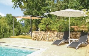 Un espace piscine avec des chaises longues et une pergola.