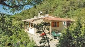A small, single-story house with a tiled roof, surrounded by dense greenery and trees. - 2 bedroom awesome home in Teyssieres (Teyssieres)