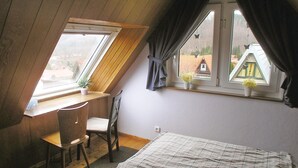 A small, sloped-roofed room with a desk, chair, and bed. - Amazing home in Langelsheim with WiFi (Langelsheim)
