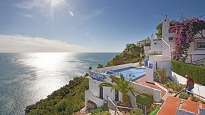 Una propiedad costera con piscina, un faro y vistas al mar.