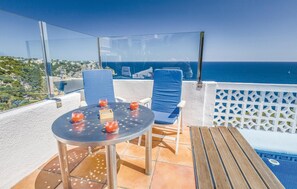 An outdoor terrace with a table and chairs, overlooking a coastal view. - Beach front home in Jávea (Jávea)