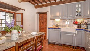 A kitchen with wooden beams, grey cabinets, and a tiled backsplash. - 3 bedroom beautiful home in Pistoia (PT) (Pistoia (PT))
