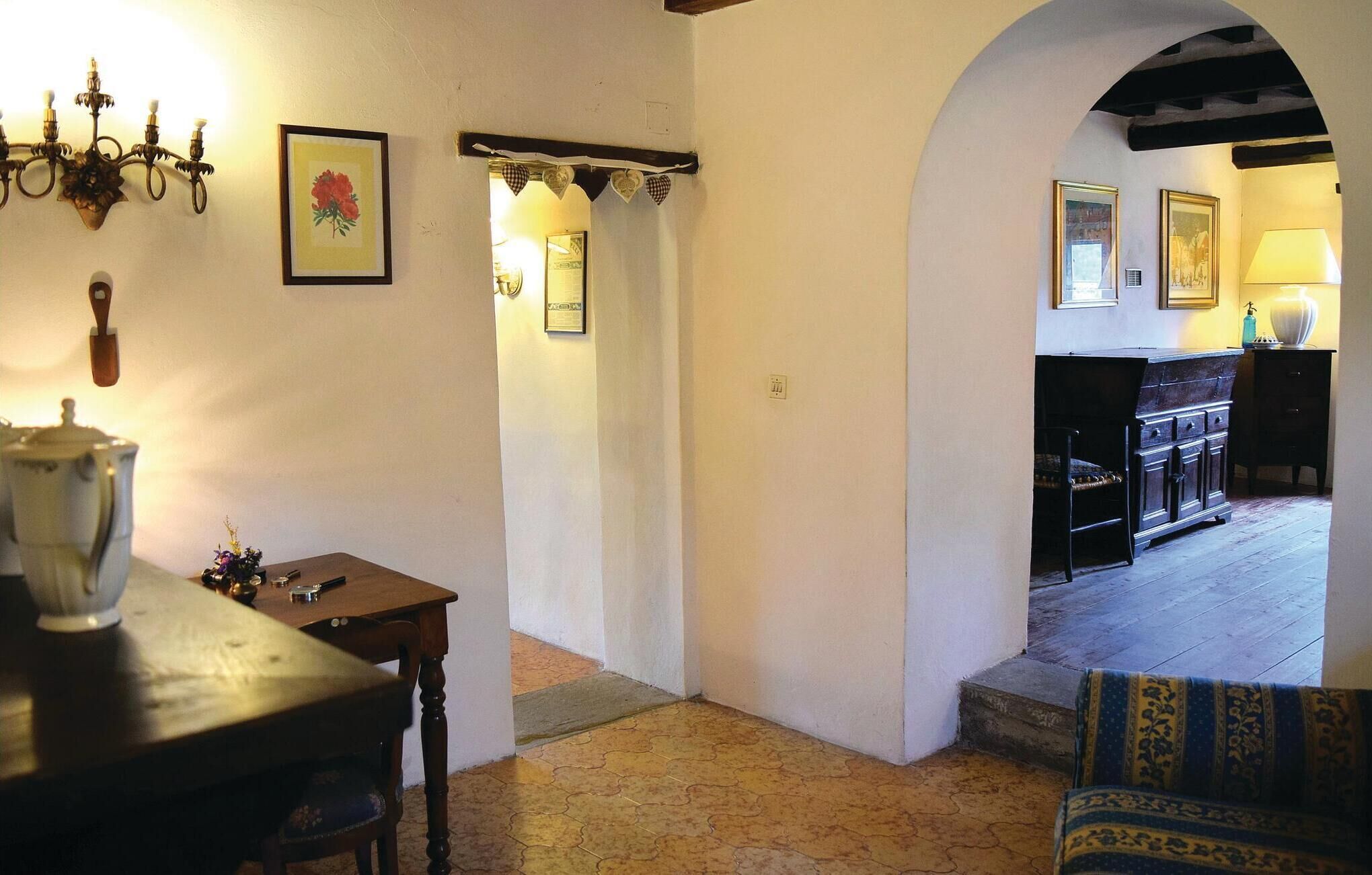 Ein gemütliches Interieur mit einem Holztisch, einer Kronleuchter und einem gerahmten Bild an der Wand.
