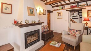 A cozy living room with a fireplace, a bookshelf, and a comfortable seating area. - 3 bedroom beautiful home in Pistoia (PT) (Pistoia (PT))