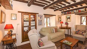 A cozy living room with a sofa, armchairs, a coffee table, and a bookshelf. - 3 bedroom beautiful home in Pistoia (PT) (Pistoia (PT))