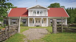 A two-story house with a red roof, white exterior, and a front porch with a gravel path leading to the entrance. - Lovely home in Tranås with kitchen (Tranås)