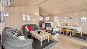 Un salon spacieux comprenant un canapé, une table basse et un coin repas avec une table et des chaises.