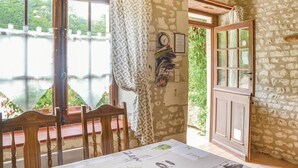 A rustic room with a stone wall, a wooden door, and a view of a bridge over a body of water. - Awesome home in Assay (Assay)