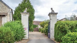 A gated entrance with stone pillars and a pathway leading to a building. - Awesome home in Assay (Assay)