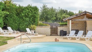 A swimming pool with lounge chairs and a stone wall. - Awesome home in Assay (Assay)