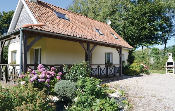 Ein traditionelles Haus mit Ziegeldach, Holzbalken und einer Schotterauffahrt.
