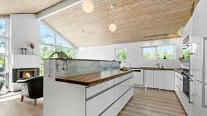A modern kitchen with a central island, wooden ceiling, and large windows. - Nice home in Knebel with sauna (Knebel)
