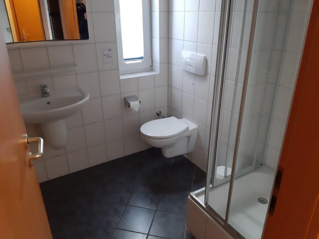 Ein Badezimmer mit Waschbecken, Toilette und Dusche.