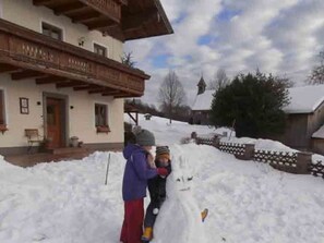 Un bâtiment doté d’un balcon et dont le sol est recouvert de neige.