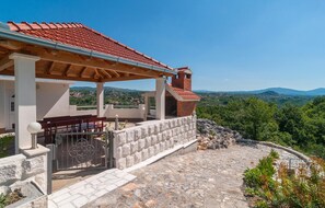 Relax in a serene villa setting with a covered patio and lush greenery.