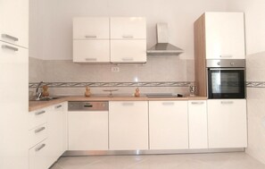 Enjoy cooking in this well-equipped kitchen with an oven, stainless steel range hood, and ample countertop space.