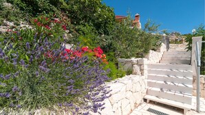 A stone staircase leading up to a building with a red roof.