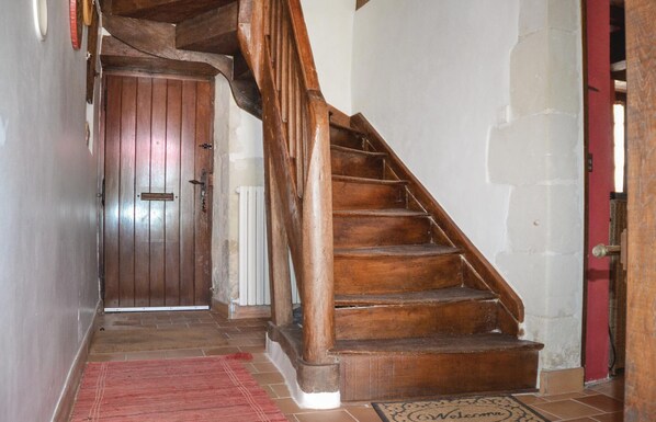 Eine Holztreppe führt zu einer Tür mit rotem Rahmen.