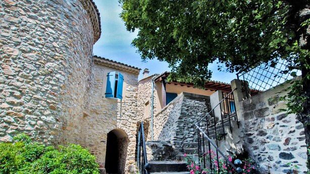 A stone staircase leading up to a building with a traditional design, surrounded by greenery and flowers. - Amazing home in Flaviac (Flaviac)