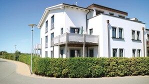 A modern two-story building with a balcony on the ground floor.