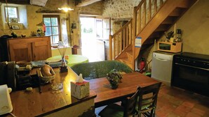 A rustic kitchen with wooden furniture, a dining table, a staircase, and a microwave. - Gorgeous home in Vernie with WiFi (Vernie)