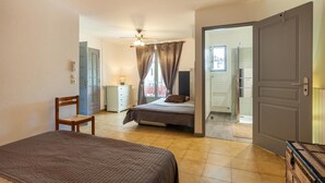 A bedroom with a bed, a chair, a dresser, and a window with curtains. - Amazing home in Signes (Signes)
