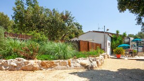 A house with a stone wall, a wooden fence, and a garden with various plants. - Amazing home in Signes (Signes)