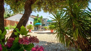 A patio area with outdoor seating, potted plants, and a view of a building in the background. - Amazing home in Signes (Signes)