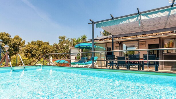 A swimming pool with lounge chairs and umbrellas, surrounded by a fence and trees. - Amazing home in Signes (Signes)