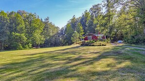 A red house surrounded by a grassy field and dense trees. - Stunning home in Annerstad with WiFi (Annerstad)