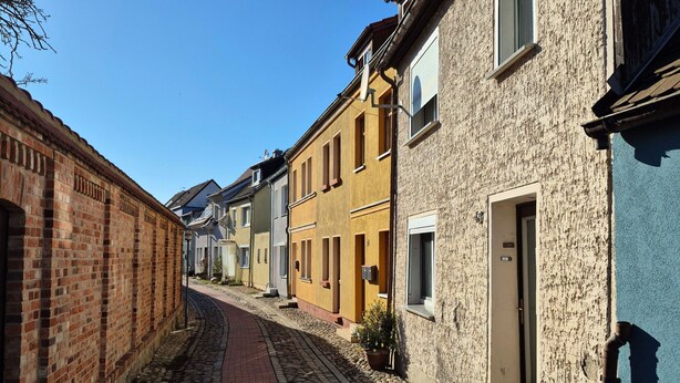 A narrow cobblestone street lined with historic buildings, featuring brick facades and traditional architecture. - Vacation home Boddenblick (Barth)