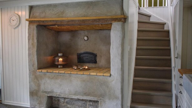 A stone fireplace with a shelf, a clock, and a small plaque. - Nice home in Löttorp with WiFi (Löttorp)