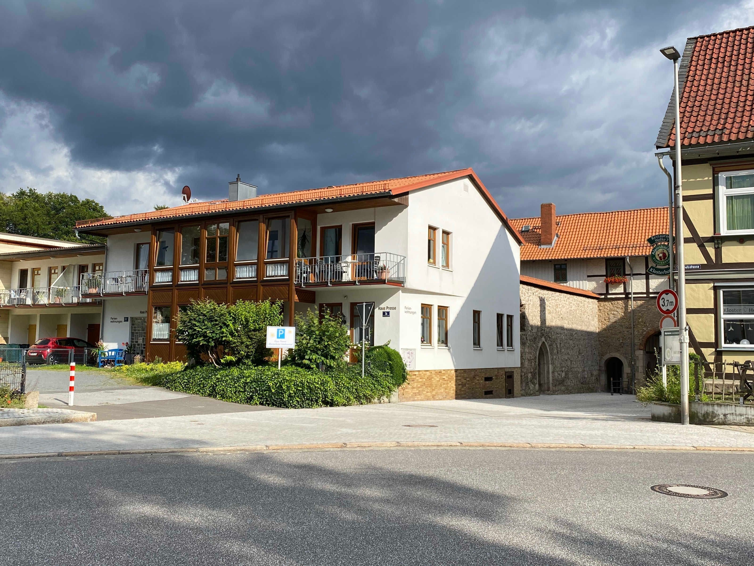 Ein zweistöckiges Gebäude mit einem Balkon, einem Parkschild und einem Verbotsschild.