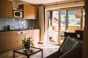 A modern kitchen with wooden cabinets, a microwave, and a dishwasher. - Üntsche Apartment - Alpenrose - Hotel - Apartments**** (Rehmen)