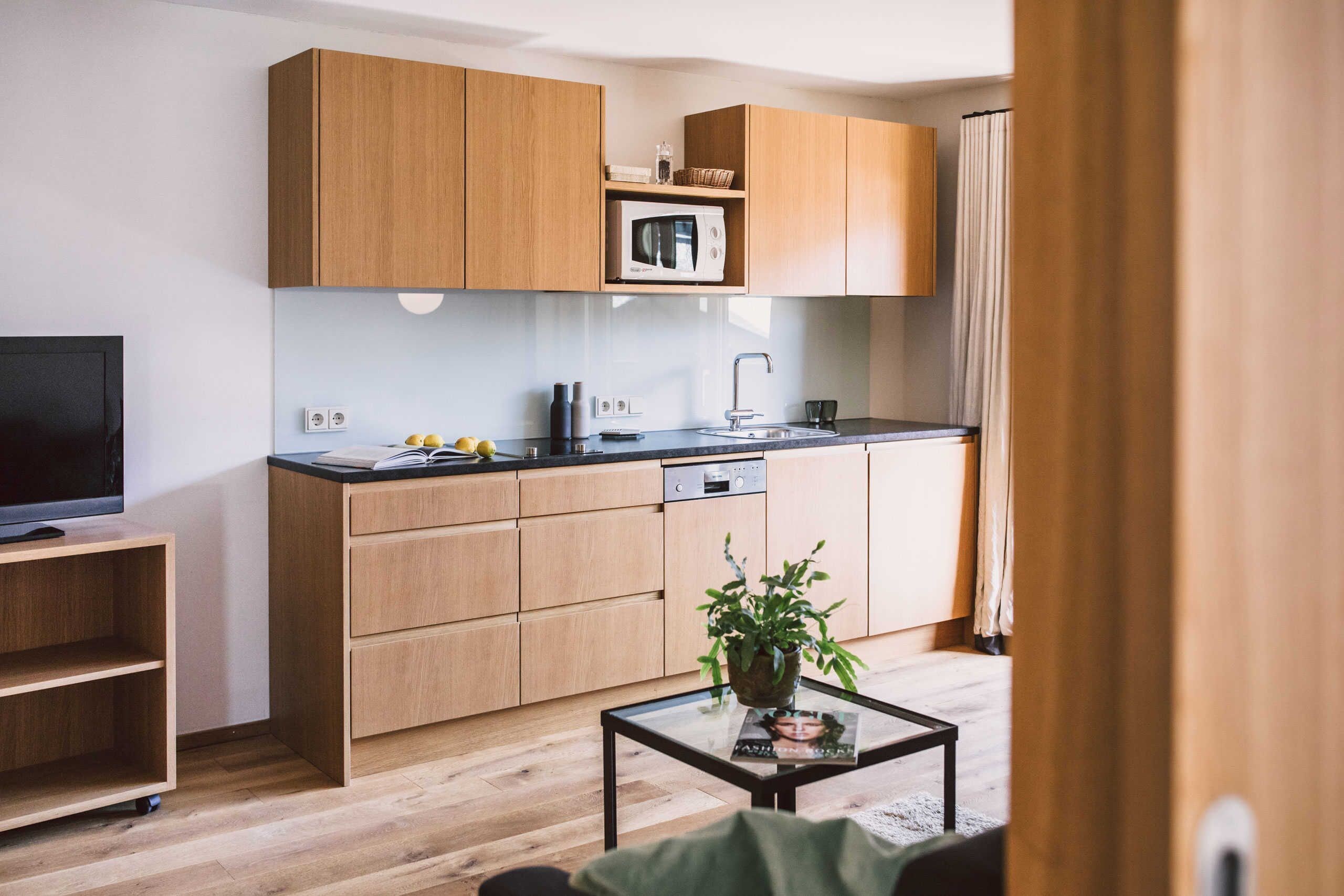 A modern kitchen with wooden cabinets, a microwave, and a sink.