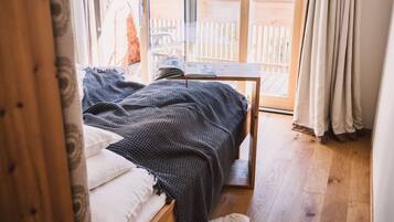 Un dormitorio con cama, una mesita y vistas al exterior.