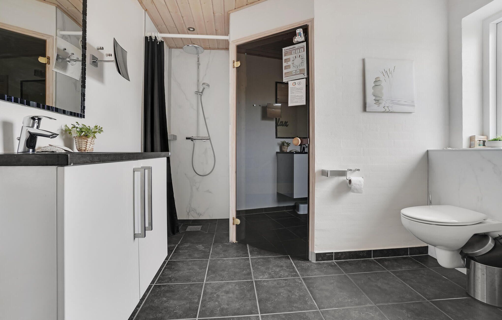 A modern bathroom with a shower, toilet, and sink.