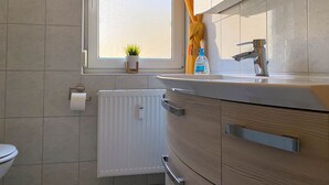 A bathroom with a window, a radiator, a sink, and a toilet. - *Forest 10 measure GM 69552 - Forest 10 - SNR: 1 (Graal-Müritz)
