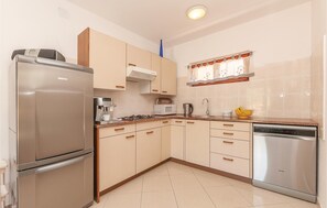 A modern kitchen with a refrigerator, microwave, stove, sink, and dishwasher. - 2 bedroom beach front apartment in Pirovac (Pirovac)
