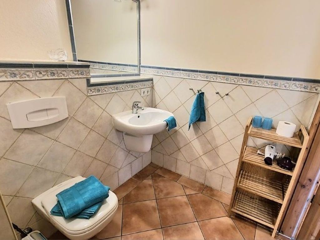 Ein Badezimmer mit Toilette, Waschbecken und Spiegel.
